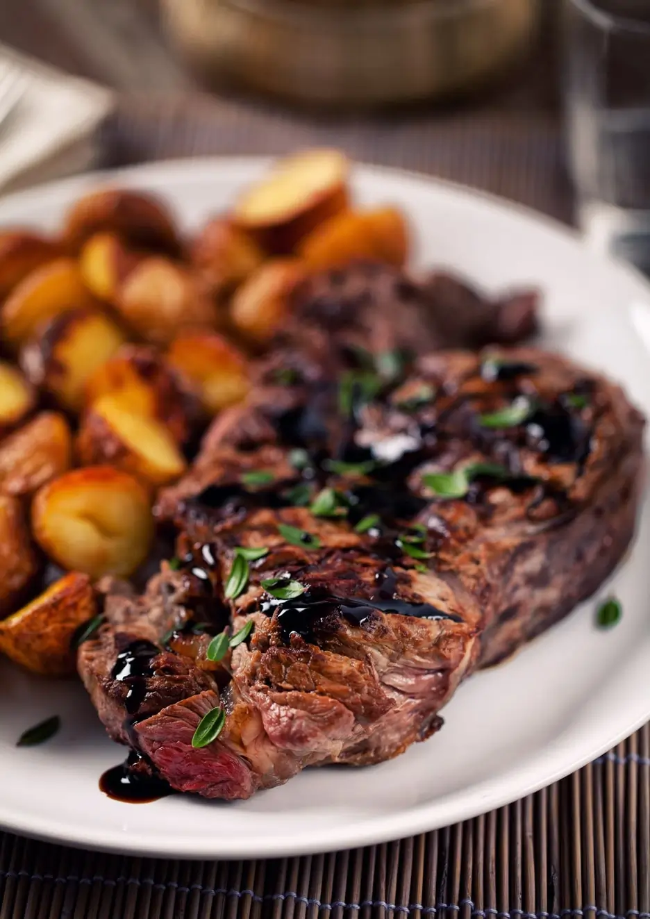 Grilled steak with herb garnish and roasted baby potatoes