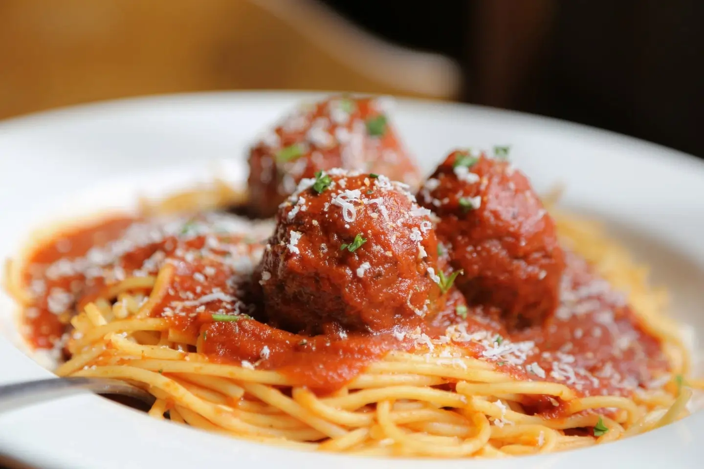 Spaghetti with tomato sauce and meatballs, topped with grated cheese